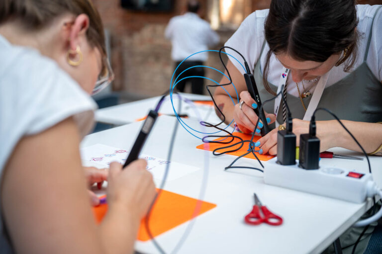 2 Frauen gestalten mit einem Extrusionsstift Kunststoffelemente